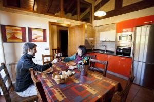 Un uomo e una donna seduti a un tavolo in una cucina di Casa rural Urederra 1 y 2, en Baquedano, donde inicia la ruta del Nacedero del Urederra a Baquedano Altre 10 foto