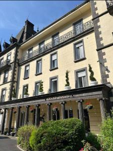a large building with a balcony on top of it at Le Grand Hôtel Mont Dore in Le Mont-Dore