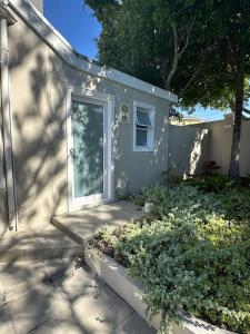 Camellia Cottage - Bay Room في كيب تاون: منزل صغير فيه باب ونافذة +8 صور