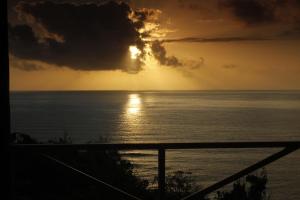 a sunset from the balcony of a house at I VIEW - in Long Bay in Port Antonio
