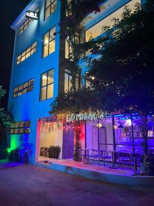 un edificio con luces moradas y azules delante de él en Wish Guesthouse, en Huraa