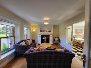 a living room with two couches and a fireplace at Reeks Country House in Killarney