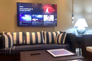 ein Wohnzimmer mit Couch und Flachbildfernseher in der Unterkunft Beira mar alto padrão! in Bertioga