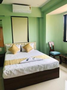 a bed in a room with a green wall at Everest Stays Rooms and Dormitory in Mumbai