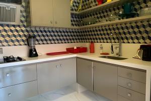 eine Küche mit weißen Schränken und einer Spüle in der Unterkunft Beira mar alto padrão! in Bertioga + 61 Fotos