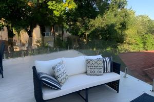 eine weiße Couch mit Kissen auf einer Terrasse in der Unterkunft Beira mar alto padrão! in Bertioga