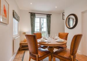 ein Esszimmer mit einem Tisch, Stühlen und einem Spiegel in der Unterkunft Cuckoo Lodge in Wighton