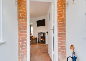 an open hallway with a brick wall and a television at Cuckoo Lodge in Wighton
