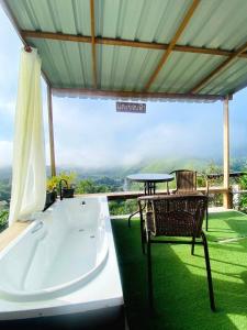 a bath tub sitting next to a table and a chair at แตะขอบฟ้าสะปัน โฮมสเตย์ in Ban Huai Ti