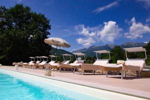 a row of chairs and umbrellas next to a swimming pool at Locanda Fermento in Mochignano