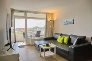 a living room with a black couch and a table at Kaiserhof App 786 inkl WLAN in Grömitz
