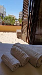 a pair of towels sitting on a bed next to a window at Sunny House - by AP Apartment in Gallipoli