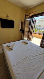 a white bed in a room with a window at Sunny House - by AP Apartment in Gallipoli