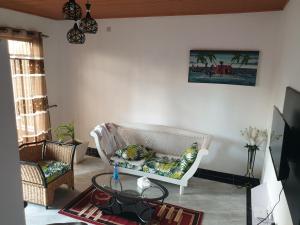 a living room with a white couch and a table at RAKA HOLIDAY HOMES in Malindi