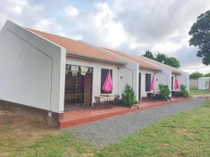 a white building with a patio with tables and chairs at RAKA HOLIDAY HOMES in Malindi
