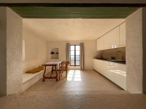 eine Küche mit einem Tisch und einem Esszimmer in der Unterkunft Seeblick und offener Kamin - Casa di Florian in Tremosine sul Garda