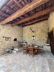 a patio with a table and chairs and a stone wall at BORGO VILLA VALENTINI in Scandiano
