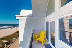 a balcony with yellow chairs and a view of the beach at Ambassador 311 in Panama City Beach