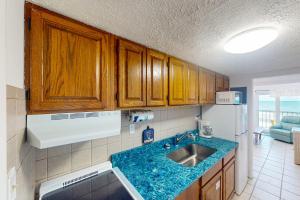 a kitchen with a sink and a blue counter top at Ambassador 311 in Panama City Beach