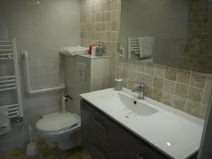 a bathroom with a sink and a toilet and a mirror at hOTEL kARINA in Jarnac