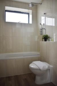 a bathroom with a toilet and a bath tub at Calming 2BR with balcony in Brentwood in Brentwood