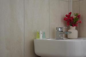a bathroom with a sink with a vase of flowers on it at Calming 2BR with balcony in Brentwood in Brentwood