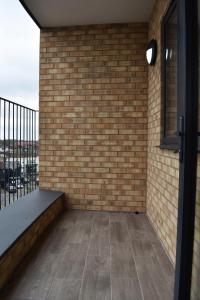 uma varanda com uma parede de tijolos e uma janela em Calming 2BR with balcony in Brentwood em Brentwood