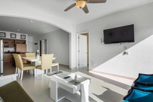 a living room with a table and a tv at Casa Aquamarina 43 - Playa Arcangel in Rosarito