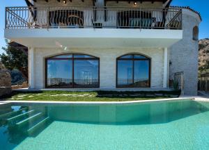 a house with a swimming pool and a balcony at Geroulios Kastro I & II, a Grand Estate, By ThinkVilla in Vatoudhiáris