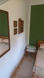 a room with two beds and a mirror and a table at Aconchego Boa Viagem in Recife