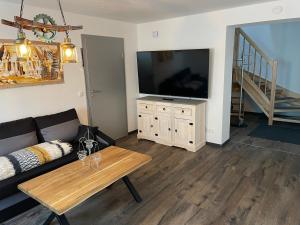 ein Wohnzimmer mit einem Sofa und einem Flachbild-TV in der Unterkunft Ferienhaus-Parsteinsee in Herzsprung