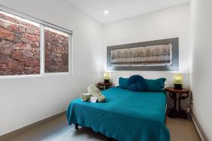 a bedroom with a blue bed and a window at Casa Aquamarina 43 - Playa Arcangel in Rosarito +30 photos