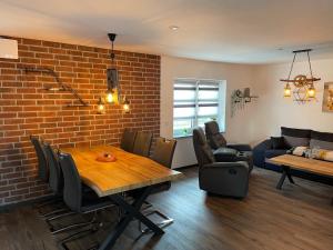 a dining room with a brick wall and a table and chairs at Ferienhaus-Parsteinsee in Herzsprung