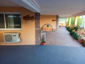 a porch of a house with a tv on the wall at Saint Thomas sea view in Preveza +6 photos