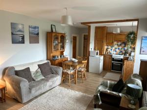 a living room with a couch and a kitchen at Glenbeigh Holiday Cottage - Tigin Mamo in Glenbeigh