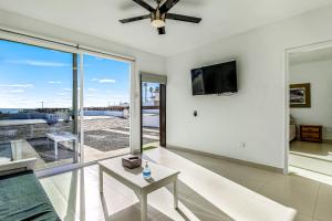 a living room with a ceiling fan and a tv at Casa Violeta 42 - Playa Arcangel in Rosarito