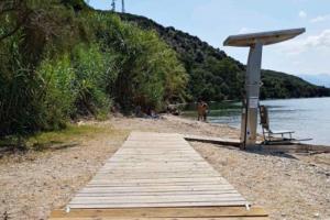 a wooden boardwalk on a beach next to the water at Saint Thomas sea view in Preveza