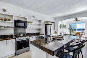 a kitchen with white appliances and a table with chairs at Casa Blanca 44 - Playa Arcangel in Rosarito