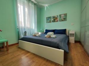 - une chambre avec un grand lit aux murs bleus dans l'établissement Gioiello nel Borgo Marinaro, à Civitanova Marche