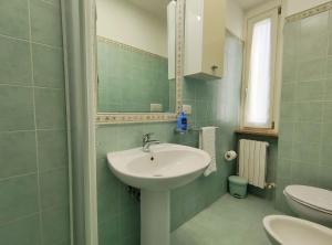 La salle de bains est pourvue d'un lavabo, d'un miroir et de toilettes. dans l'établissement Gioiello nel Borgo Marinaro, à Civitanova Marche