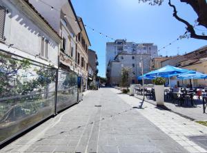 une rue vide dans une ville avec des tables et des parasols dans l'établissement Gioiello nel Borgo Marinaro, à Civitanova Marche