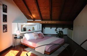 sypialnia z dużym łóżkiem i drewnianym sufitem w obiekcie Civico 24 w mieście Cremona