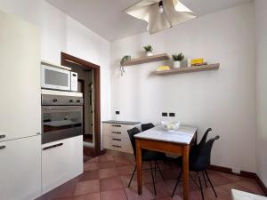 uma pequena cozinha com uma mesa e um micro-ondas em Civico 24 em Cremona