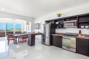 a kitchen with stainless steel appliances and a dining table at Casa Fresno 23 - Playa Arcangel in Rosarito
