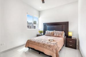 Un dormitorio con una cama grande y una ventana en Casa Fresno 23 - Playa Arcangel en Rosarito