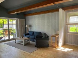 a living room with a blue couch and a table at Hotel Waldhaus Prieros in Prieros