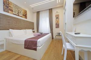 ローマにあるAlla Locanda Malandraのベッドとデスクが備わるホテルルームです。