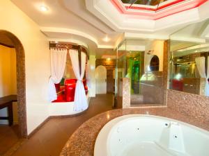 een grote badkamer met een bad en een slaapkamer bij Motel Camelot in São Leopoldo