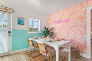 a dining room with a white table and chairs at Pink Flamingo in Dunedin