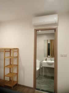 a bathroom with a sink and a toilet and a mirror at FThomestay at Vinhome Grand Park HCM in Gò Công
